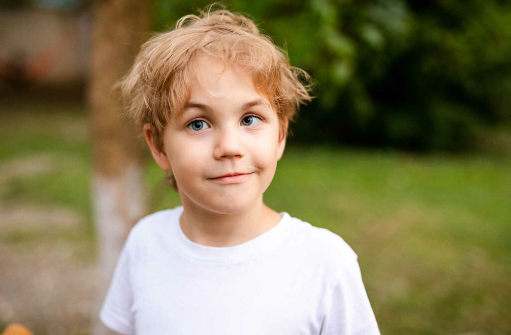 Young boy at the park with evidence of strabismus in his left eye.