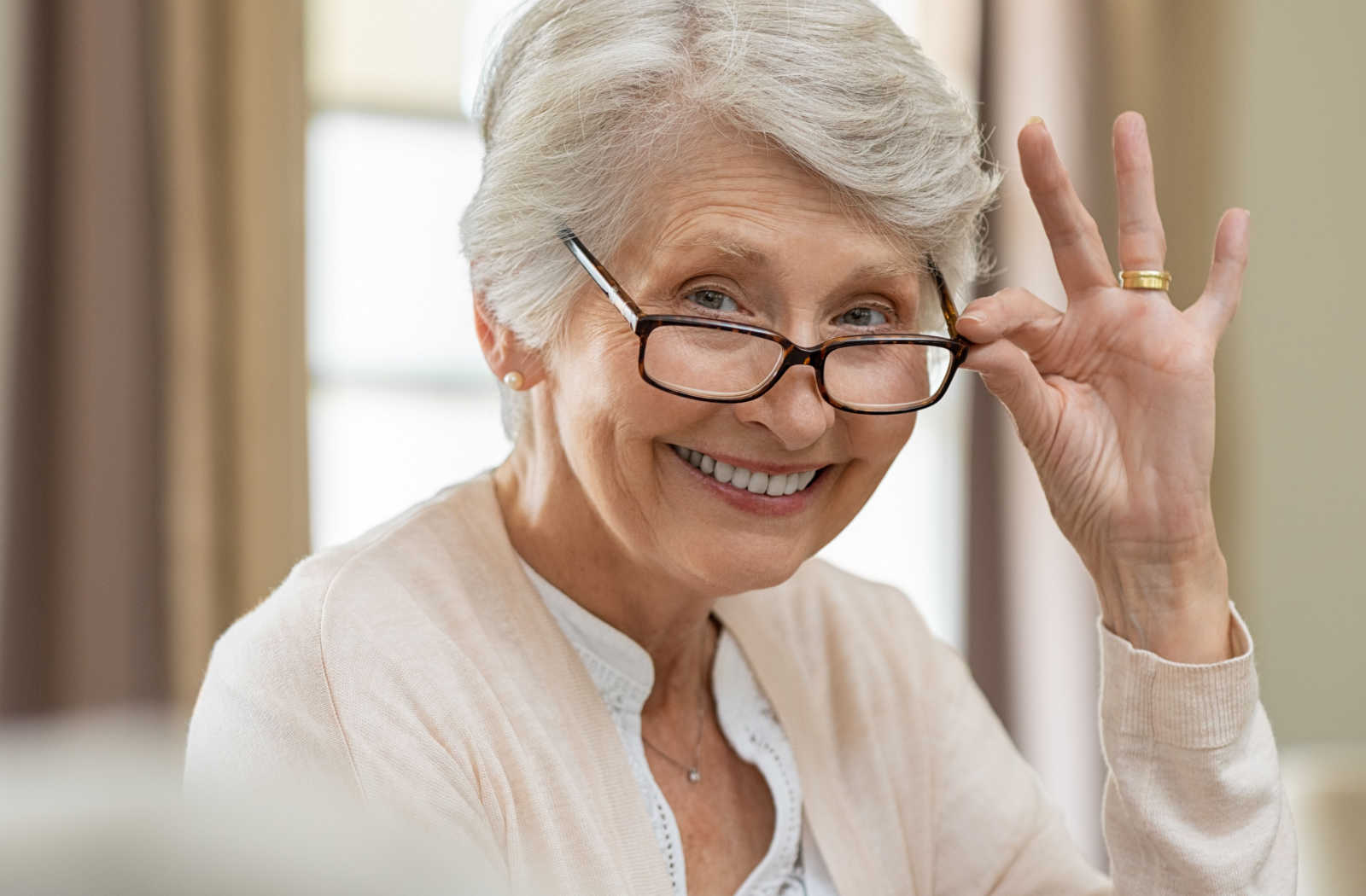 A senior woman and her male optometrist performing an eye exam using a medical device to detect eye problems.