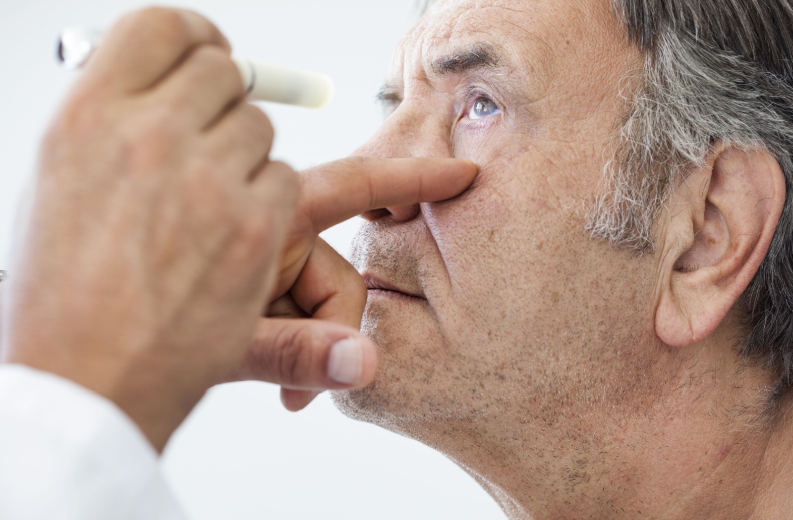 An older adult man getting examined for glaucoma.